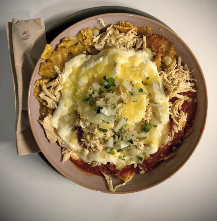 Chilaquiles divorciados con pollo, mitad salsa verde y mitad salsa roja, nata y cebolla