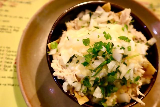 Chilaquiles con pollo, cebolla y cilantro