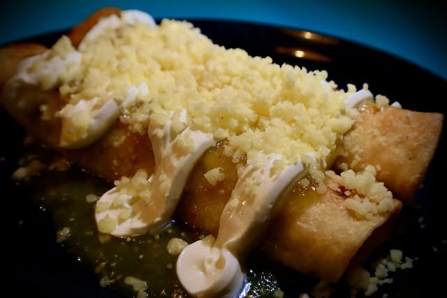 Flautas bañadas en salsa verde con nata y queso